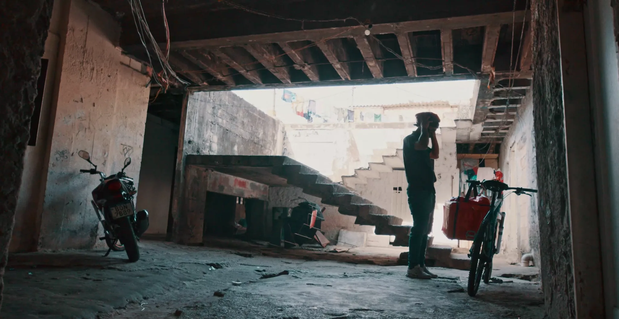 Entregador ao lado da bicicleta com bag de entrega, em uma garagem, em filme da série BBC StoryWorks produzido pela Brick